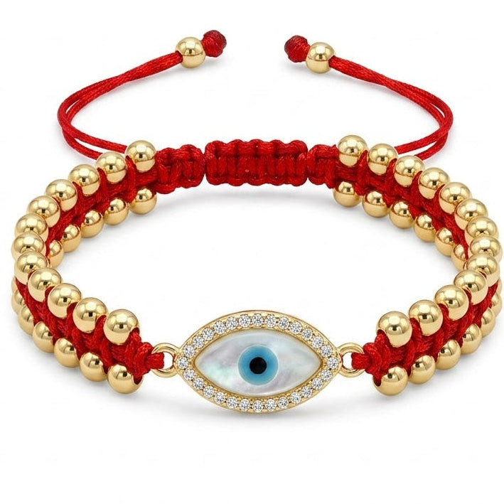 Red braided evil eye bracelet featuring polished gold beads and a central oval blue evil eye charm. The charm is surrounded by sparkling clear crystals, with adjustable red cord ends and gold bead accents. Displayed on a clean white background.