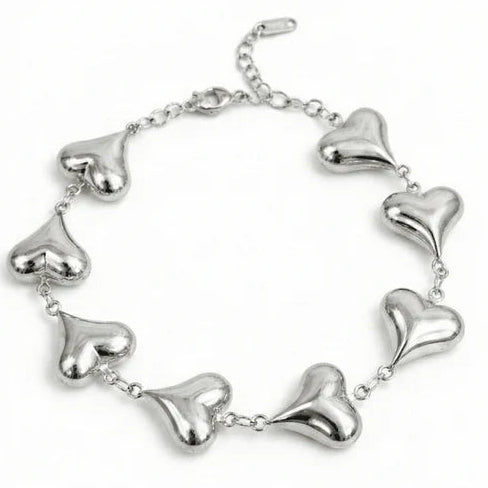 Silver-tone bracelet featuring multiple polished heart-shaped charms linked around the band, with an adjustable chain clasp.