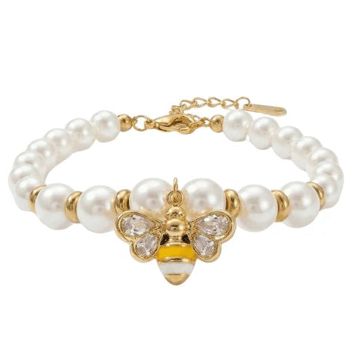 Gold-tone pearl bracelet featuring a strand of round white pearl-like beads and a central bee charm with crystal-encrusted wings and body details.
