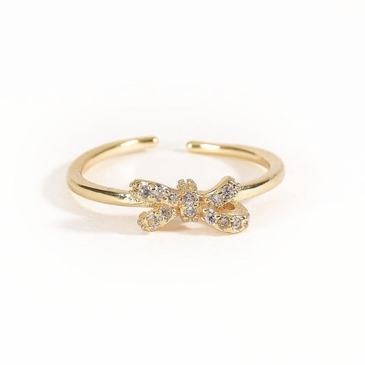 Dainty bow ring with sparkling crystal accents and an anti-tarnish gold finish, perfect for everyday wear, feminine styling, and thoughtful gifting.
