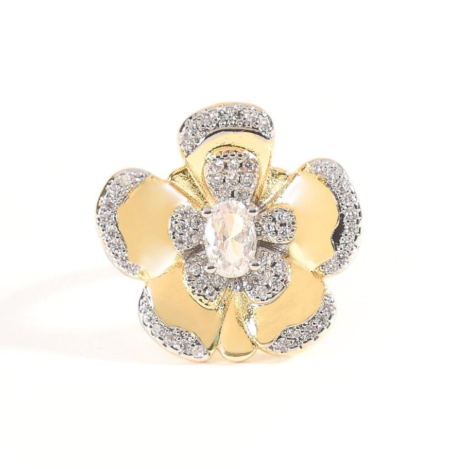 Gold-tone statement flower ring featuring layered petals with sparkling clear crystal accents and a prominent oval-cut centre stone. An intricate floral design with a polished gold finish, perfect for adding an elegant, eye-catching touch to any outfit.