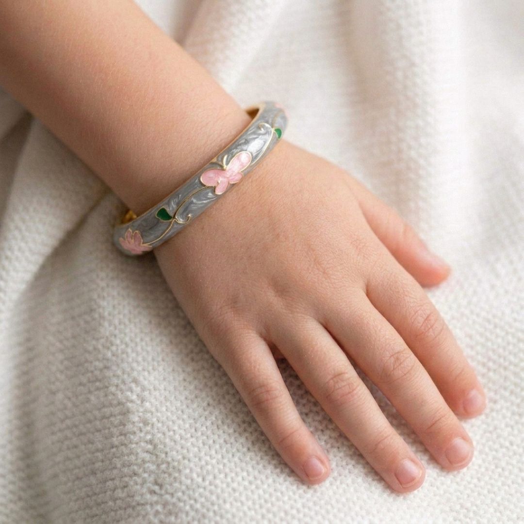Kids' floral enamel bangle with colorful pastel flower detailing and an anti-tarnish gold finish, perfect for comfortable everyday wear, playful styling, and special occasions.