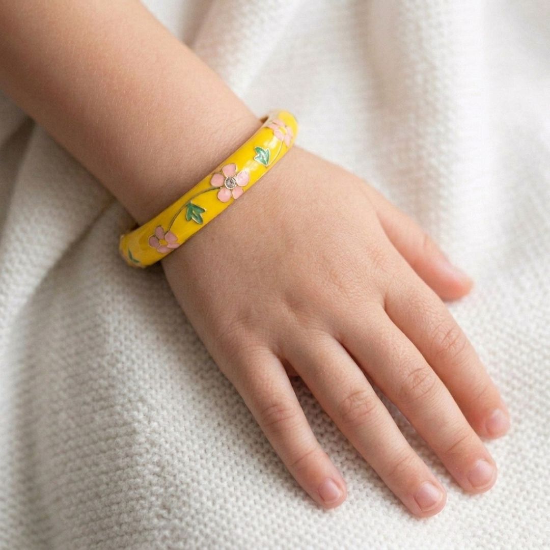 Kids' floral enamel bangle with colorful pastel flower detailing and an anti-tarnish gold finish, perfect for comfortable everyday wear, playful styling, and special occasions.