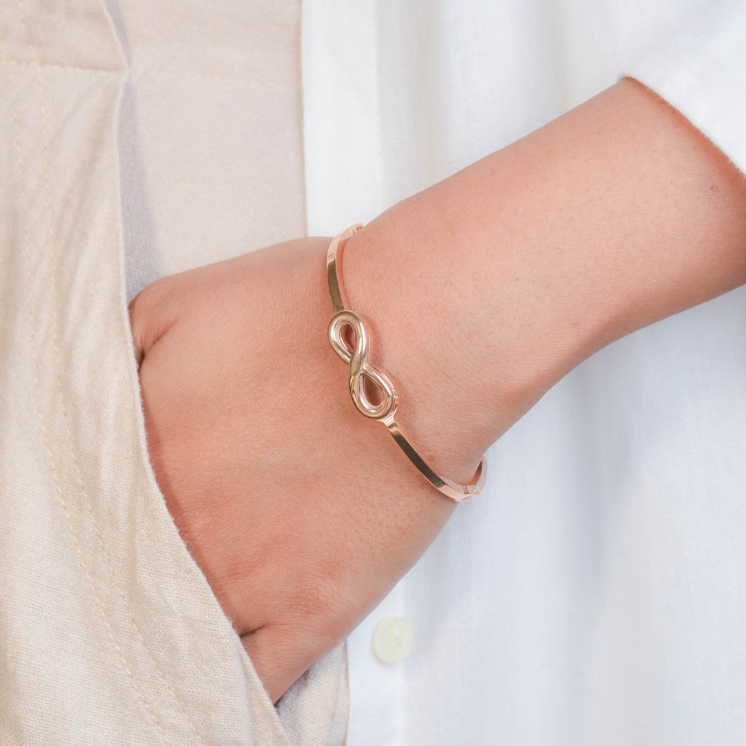 Infinity bangle with a sleek infinity motif and an anti-tarnish finish, available in gold and rose gold, perfect for everyday wear, meaningful styling, and timeless elegance.
