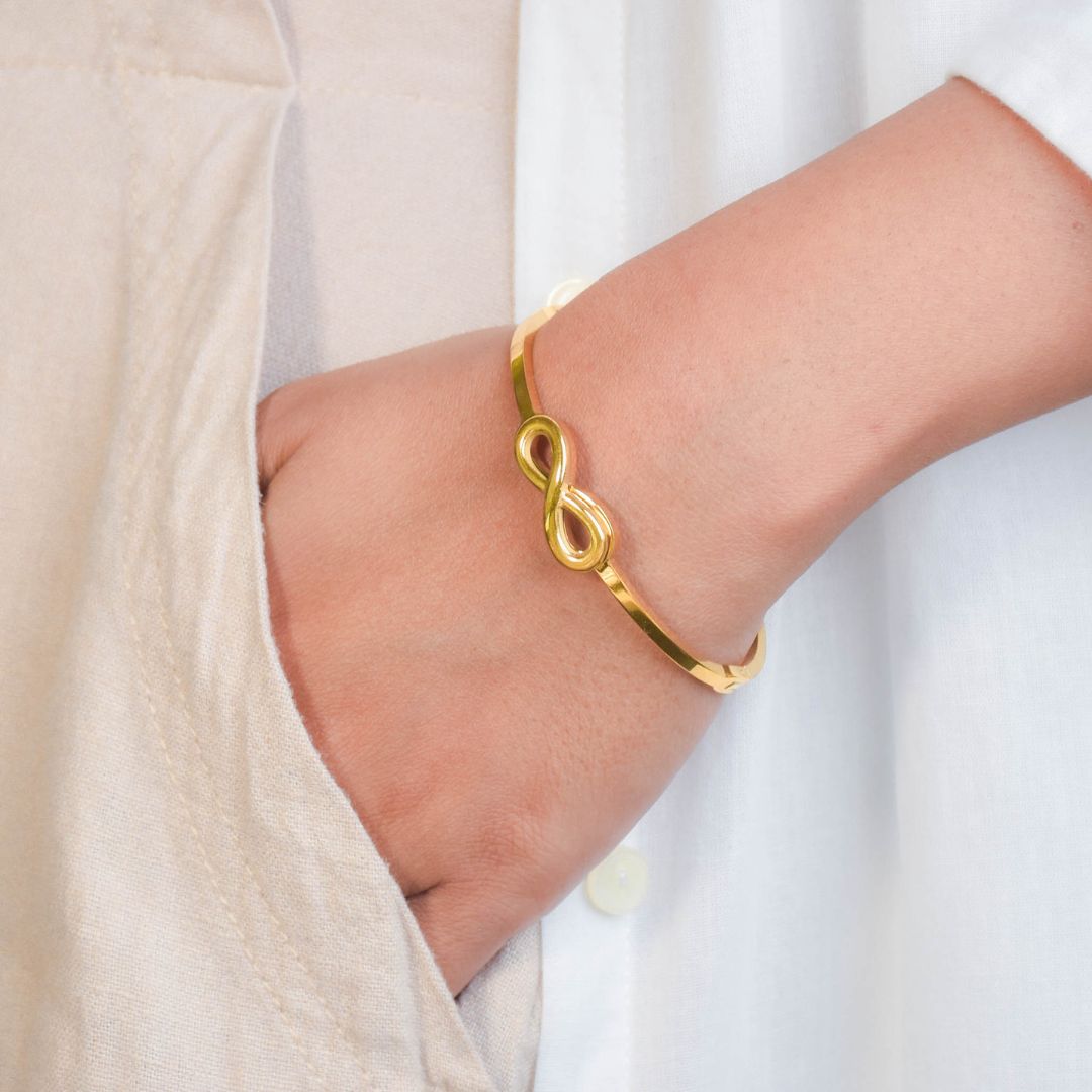 Infinity bangle with a sleek infinity motif and an anti-tarnish finish, available in gold and rose gold, perfect for everyday wear, meaningful styling, and timeless elegance.
