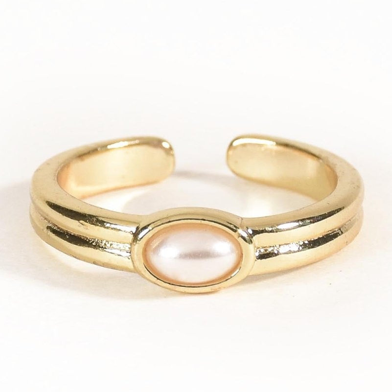 Gold-tone open band ring featuring a smooth oval pearl centrepiece set in a polished bezel, with a sleek double-line band design. Its timeless, minimalist style adds an elegant touch to everyday wear and special occasions.