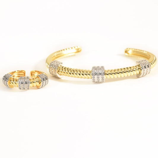 Gold twisted stainless steel open cuff bangle and matching adjustable ring set featuring sparkling crystal-studded barrel accents. Finished with a high-polish coating and displayed on a clean white background, this elegant jewelry set blends modern texture with timeless luxury.