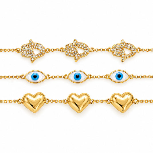 Three gold-plated chain bracelets displayed horizontally on a clean white background: a crystal-studded star-and-heart bracelet, a blue Evil Eye bracelet, and a polished gold heart bracelet.