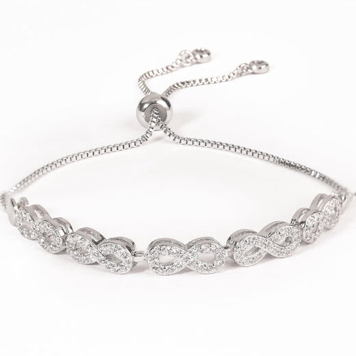 Silver-tone adjustable bracelet featuring a row of interlocking infinity-shaped links embellished with clear crystals, finished with a sliding bead closure.