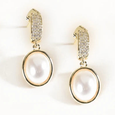 Gold-tone drop earrings featuring large oval white pearl-like stones with crystal-studded rectangular huggie tops.