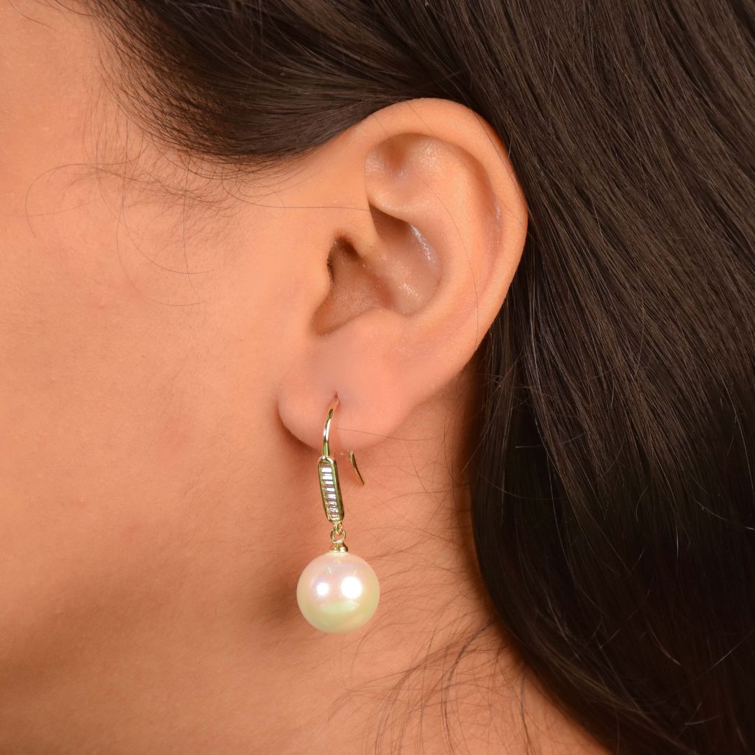 Luminance pearl earrings with baguette crystal detailing and an anti-tarnish finish, available in gold and silver, perfect for everyday wear and elegant styling.
