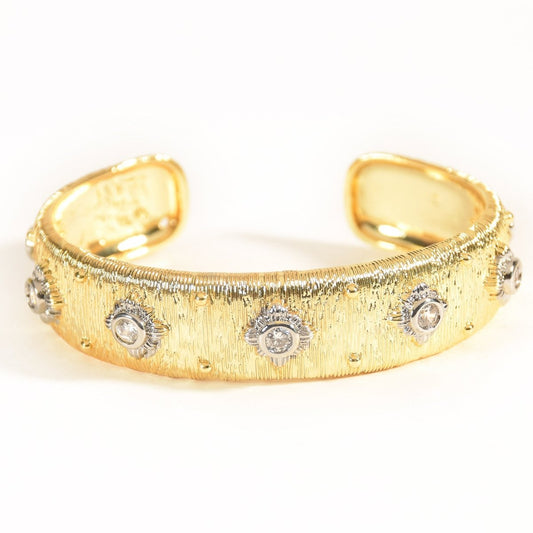 Gold textured open cuff bangle crafted from stainless steel, featuring sparkling round stones set in silver-tone sunburst bezels across the band. Finished with a high-polish anti-tarnish coating and displayed on a clean white background.