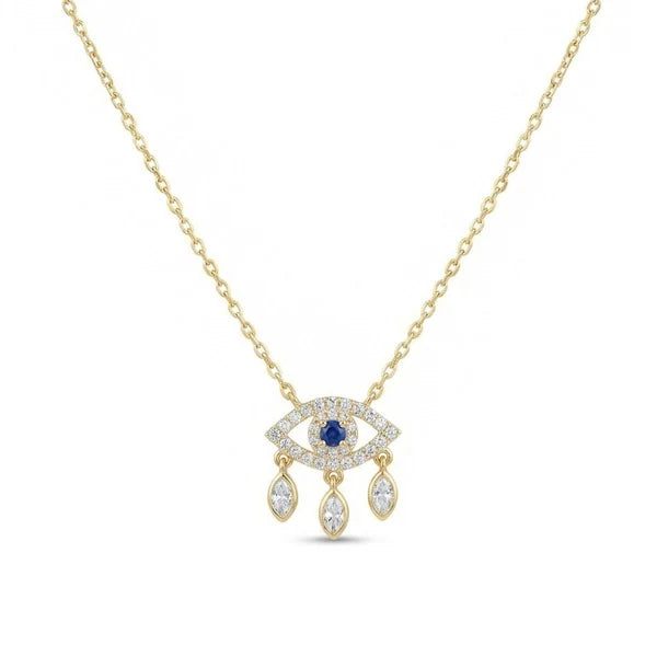 The image shows a delicate gold-toned necklace with an eye-shaped pendant. The pendant is outlined with clear pavé-style stones, features a deep blue central stone, and has three dangling teardrop-shaped crystal charms along the bottom. It is photographed against a clean white background.
