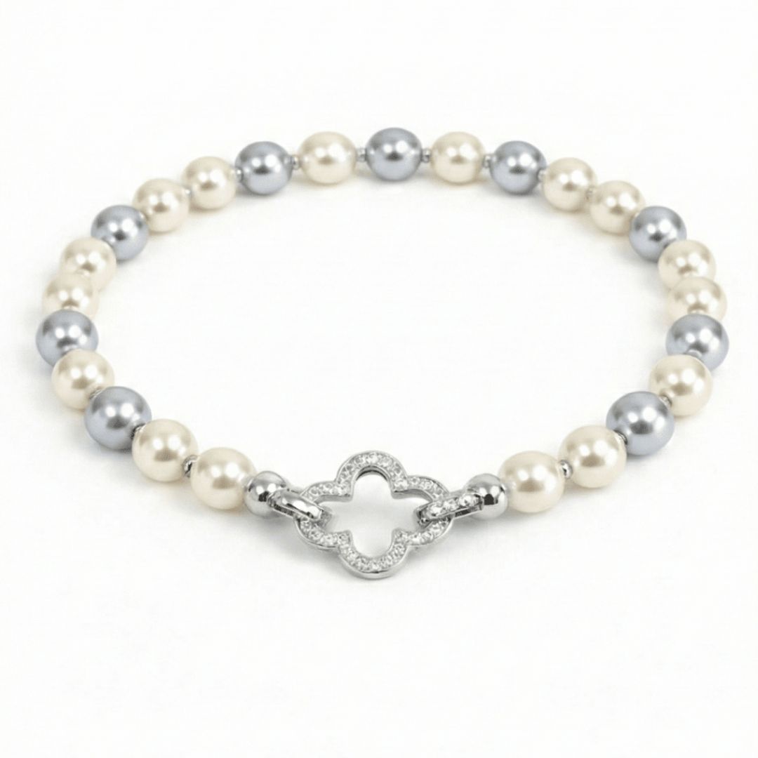 Pearl bracelet with mixed pearl detailing and a crystal clover clasp, finished with an anti-tarnish coating, perfect for everyday wear and elegant styling.
