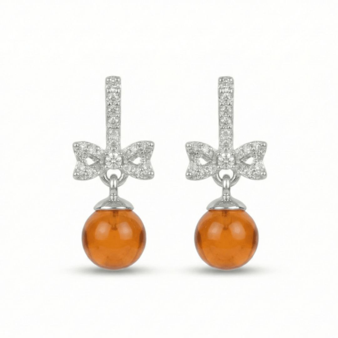 Persimmon drop earrings with crystal bow and orange bead detailing, finished with an anti-tarnish silver finish, perfect for everyday wear and elegant styling.
