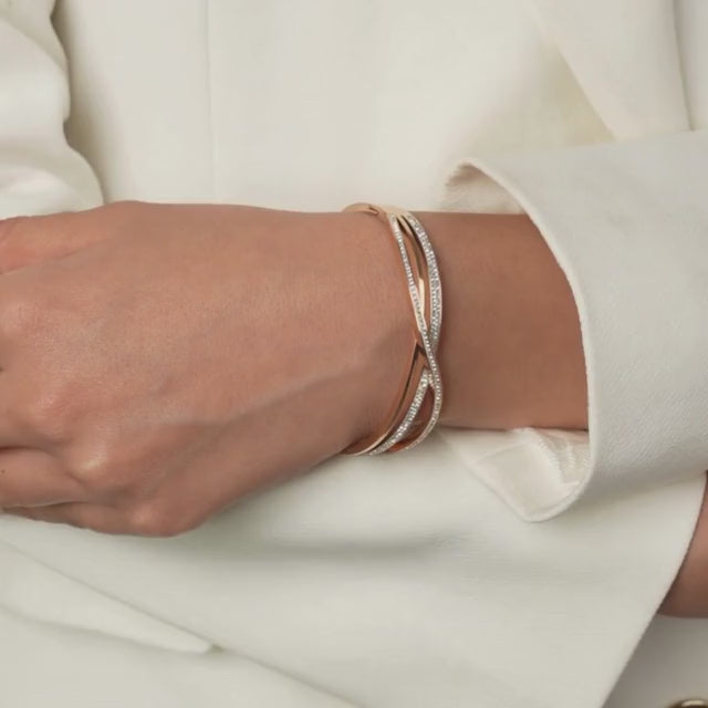Intertwined studded bangle with shimmering crystal accents and an anti-tarnish rose gold finish, perfect for everyday elegance, special occasions, and effortless stacking.
