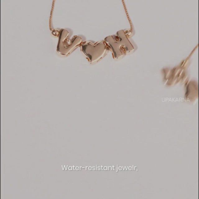 Video featuring personalized gold-tone initial jewelry, including a name necklace and matching bracelets, styled on a model’s wrist. The video highlights water-resistant everyday wear, bracelet stacking, and matching personalized bracelets with girlfriends.