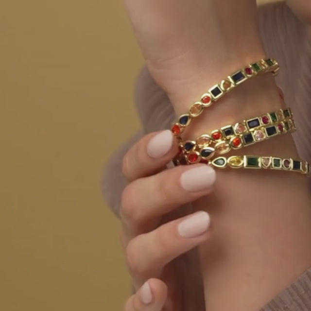Stylish multi-colored cuff bangle with heart, pearl, and geometric charm detailing and an adjustable anti-tarnish finish, perfect for playful stacking, everyday glam, and trendy statement styling.
