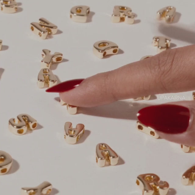 Video showcasing personalized name jewelry, with gold-tone letter charms, a necklace being assembled, and a woman wearing a personalized name necklace. The video highlights the personal touch of seeing your name in jewelry.
