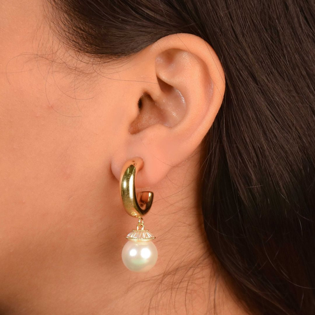 Timeless pearl drop hoops with pearl and crystal detailing and an anti-tarnish gold finish, perfect for everyday wear and elegant styling.
