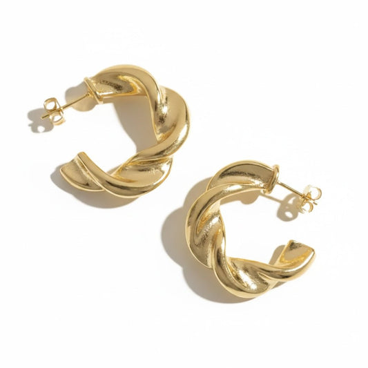 Twisted hoop earrings with a sculptural design and an anti-tarnish finish, available in gold and silver, perfect for everyday wear and modern styling.