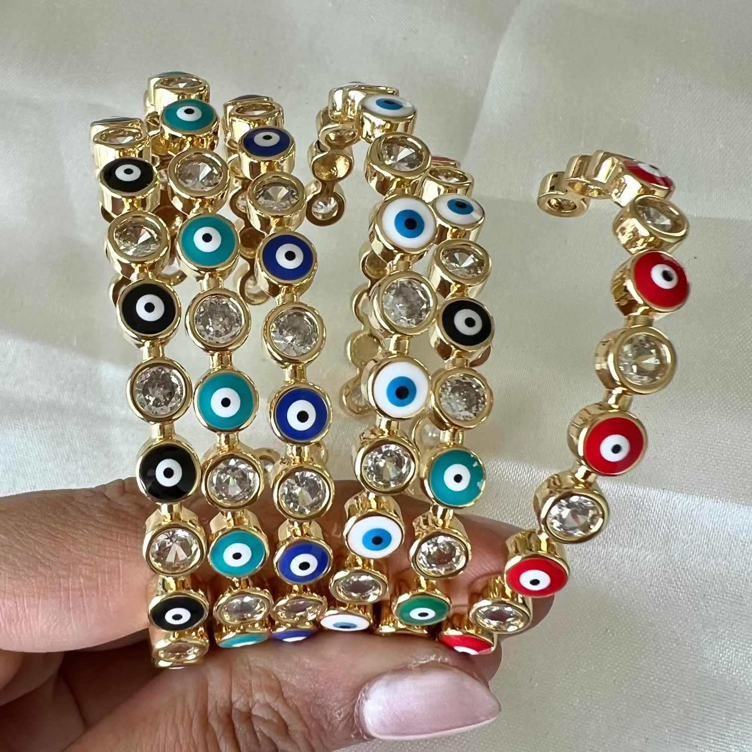 Stylish evil eye cuff bangles crafted in stainless steel with an adjustable design, available in black, blue, red, white, green, and rainbow shades, perfect for everyday wear and trendy protective styling.
