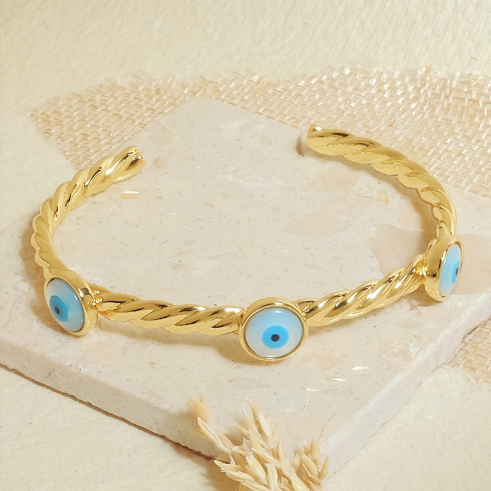 Elegant golden evil eye rope cuff bangle with an adjustable anti-tarnish finish, perfect for trendy everyday styling, chic stacking, and adding a stylish protective touch to any look.